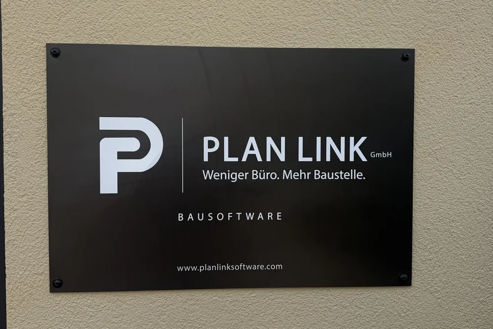 Firmenschild der PlanLink GmbH am Bürogebäude: Weniger Büro. Mehr Baustelle. Bausoftware.